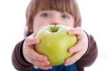 ilustrační obrázek - dítě podává jablko