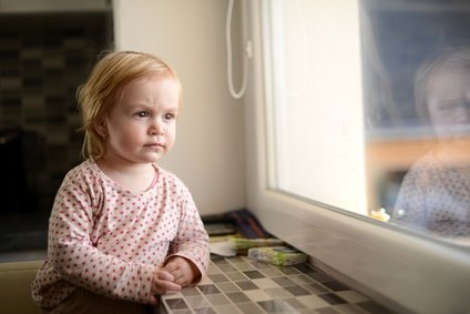 ilustrační foto: smutná holčička za oknem