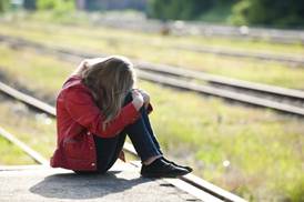 ilustrační obrázek - smutná dívka u kolejí
