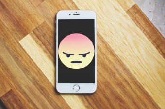 Rozzlobený smajlík na displeji mobilního telefonu Rozzlobený smajlík na displeji mobilního telefonu