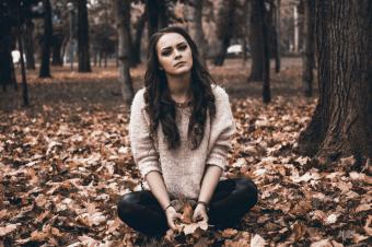 Dívka, sedící v listí