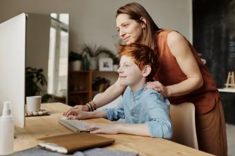 Matka pomáhá synovi s prací na počítači