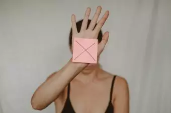 žena s rukou před obličejem