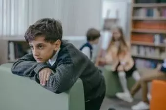Smutný chlapec opřený o stůl