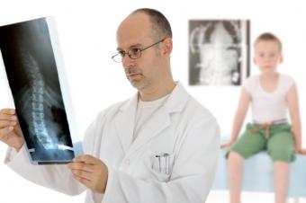 Lékař studující rentgenový snímek hocha, který je v pozadí