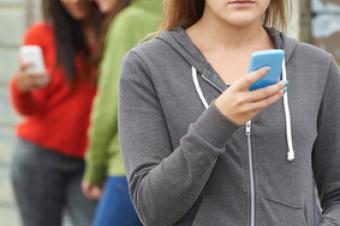 Smutná dívka hledí do mobilního telefonu Smutná dívka hledí do mobilního telefonu