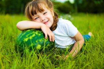 Dívka s melounem v trávě
