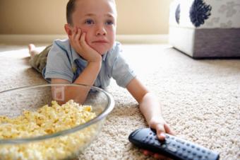 Dítě s popcornem před televizí