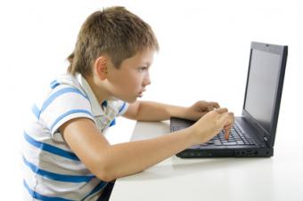 Chlapec sedící u laptopu Chlapec sedící u laptopu