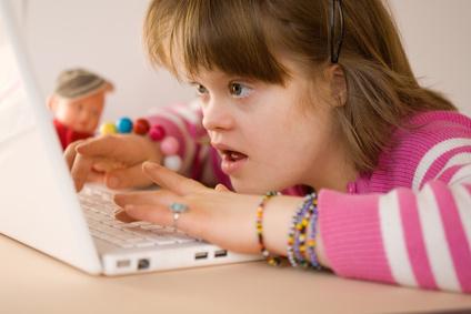 Mentálně postižená dívka a laptop Mentálně postižená dívka a laptop