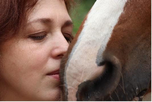 Žena se tiskne ke koni