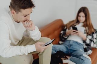 Mladí lidé se dívají na své mobilní telefony