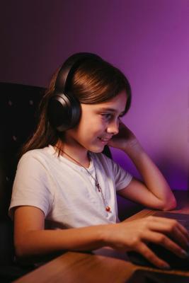 Dívka se sluchátky pracuje na počítači