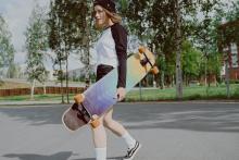 Dívka nese skateboard