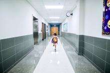Dítě běží po školní chodbě