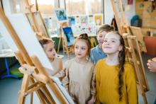 Děti stojí u malířského plátna