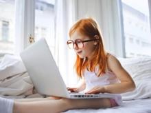 Dívka s brýlemi se dívá do počítače