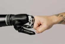 ruka člověka a ruka robota