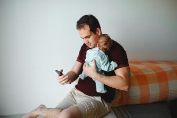 muž s miminkem a mobilem