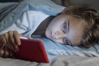 Dívka se dívá na mobilní telefon