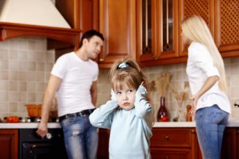 Hádající se rodiče a dívka si zacpává uši