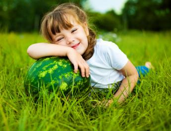 Dívka s melounem na trávě