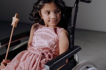 Dívka v kostýmu na vozíku