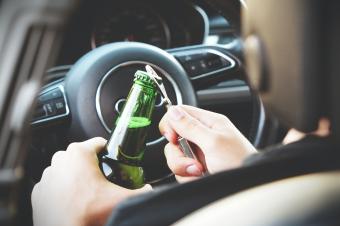 Řidič s lahví piva za volantem