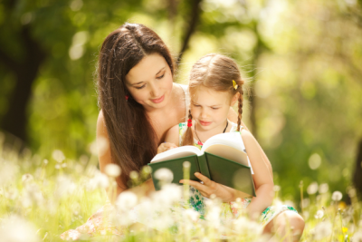 Dcera si čte s matkou v přírodě