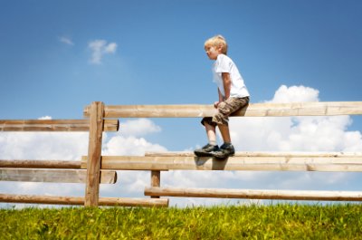 chlapec sedící na plotě