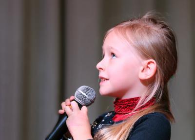 Dívka mluví do mikrofonu