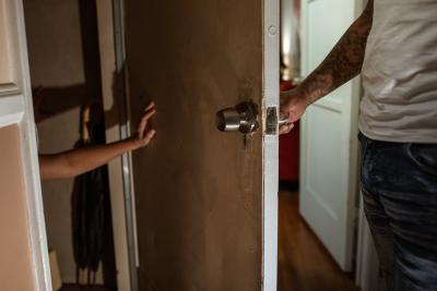 muž zavírá ženu za dveře 