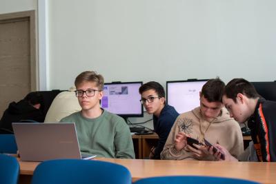 Žáci ve třídě se dívají na mobil